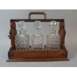 An Edwardian Oak Three Bottle Tantalus with Silver Plated Mounts Stamped 'The Tantalus' 35cm Wide.