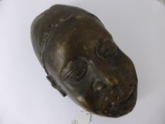 An African Bronze Mask of a Warrior, depicted wearing a pierced helmet, approx 32 cms