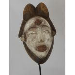 A Punu (West African) Mask, a feminine mask with elaborate coiffure ,white kaolin pigment to her