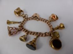 An Antique 9ct Yellow Gold Curb Link Charm Bracelet, the bracelet has nine charms including an