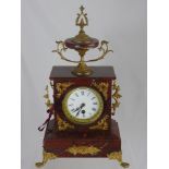 A Reproduction Red Marble Clock, with white enamel Roman numeral dial, gilt supports and