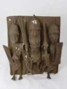 A Benin (West Africa) Plaque, patinated bronze depicting a relief study of three tribal warriors,