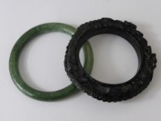 A Chinese Black Hard Stone Bangle, depicting chasing dragons and flaming pearls of wisdom together