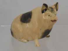 An Antique Pottery Pig, the pig with sponge paint decoration, approx 15 cms in height. (af)