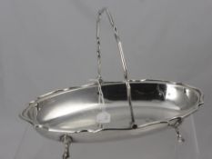 An Oval Silver Fruit Basket, on hoof feet, with scalloped edge and decorative handle, Sheffield