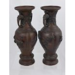 A Pair of Bronzed Vases, with decorative handles, the vase depicting birds in flight in relief,