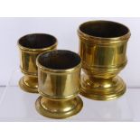 A Trio of Brass Graduated Candle Holders, together with a fireside copper kettle. (4)