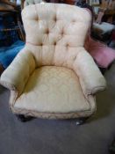 An Edwardian Arm Chair, on turned feet, with peach upholstery.