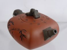 A Terracotta Oriental Tea Pot, with character marks and bat finial to the lid, possibly Korean.