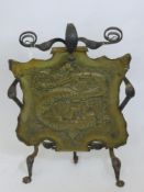 An Arts & Crafts Hammered Brass and Wrought Iron Fire Screen, depicting a chasing dragon, approx