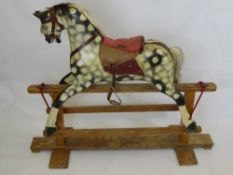 A Vintage Dappled Grey Rocking Horse, with saddle, bridle and horse hair mane and tail.