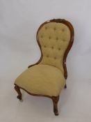 A Victorian Button Back Nursing Chair, on cabriole feet with casters, decorative carving to