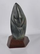 A Polished Soapstone Inuit Carving, depicting a mask of simplistic form, approx 16 cms, mounted on a