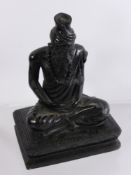 An Oriental Black Soapstone Carving of a Wise Man, depicted seated cross legged on a plinth,