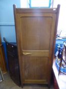 A Gordon Russell English Oak Cupboard, single door with carved handle, internal hanging rail, raised