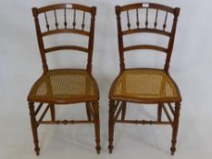 A Pair of Spindle Back Bedroom Chairs, with cane seats, turned legs and stretchers. (2)