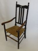An Antique Oak Kitchen Chair, of generous proportions and rush seating.