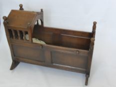 A Mahogany Infant Cradle, in the Jacobean style with hinged canopy and decorative carving.