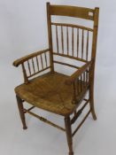 An Oak American Style Chair, with rush seat, turned legs and stretchers.