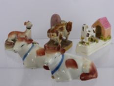 A Collection of porcelain, including two cows, a seated grey hound and a spaniel cocking his leg.(