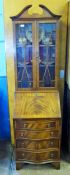 A Reproduction Bureau Bookcase, with glazed doors and writing slope and four graduated drawers