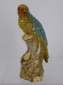 A Ceramic Yellow Glaze Parrot, seated on a naturalistic base, approx 30 cms.