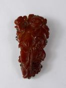 An Antique Chinese Amber Carved Clip Brooch, in the form of a wise man.