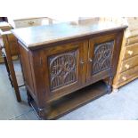 An Elizabethan Style Oak Sideboard, the sideboard having carved front panel on turned legs with