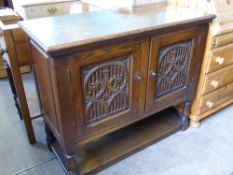 An Elizabethan Style Oak Sideboard, the sideboard having carved front panel on turned legs with