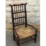An Antique Oak North Country Spindle Back Chair, with rush seating and front stretcher unusually