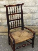 An Antique Oak North Country Spindle Back Chair, with rush seating and front stretcher unusually