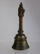 An Antique Mixed Metal Hand Bell, the bell having a ribbed handle with the Hindu deity Lakshmi to