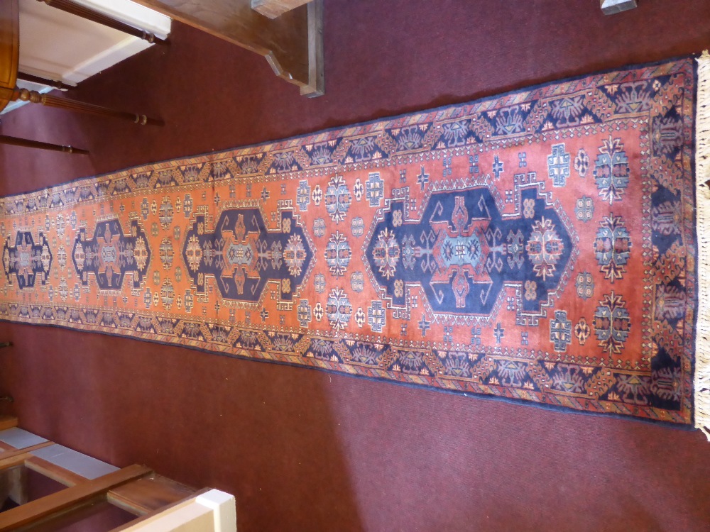 A 20th Century Iranian Wool Runner, navy blue on pink ground with four central gül, approx 415 x