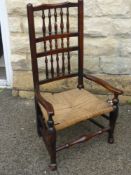 An Antique Oak North Country Spindle Back Chair, with rush seating and front stretcher unusually