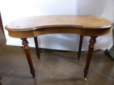 An Edwardian Walnut Kidney Shaped Writing Desk, on turned legs with porcelain casters.