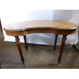 An Edwardian Walnut Kidney Shaped Writing Desk, on turned legs with porcelain casters.