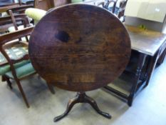 An Antique Oak Tilt Top Table, the table having turned column with hoof feet, approx 79 x 69 cms.