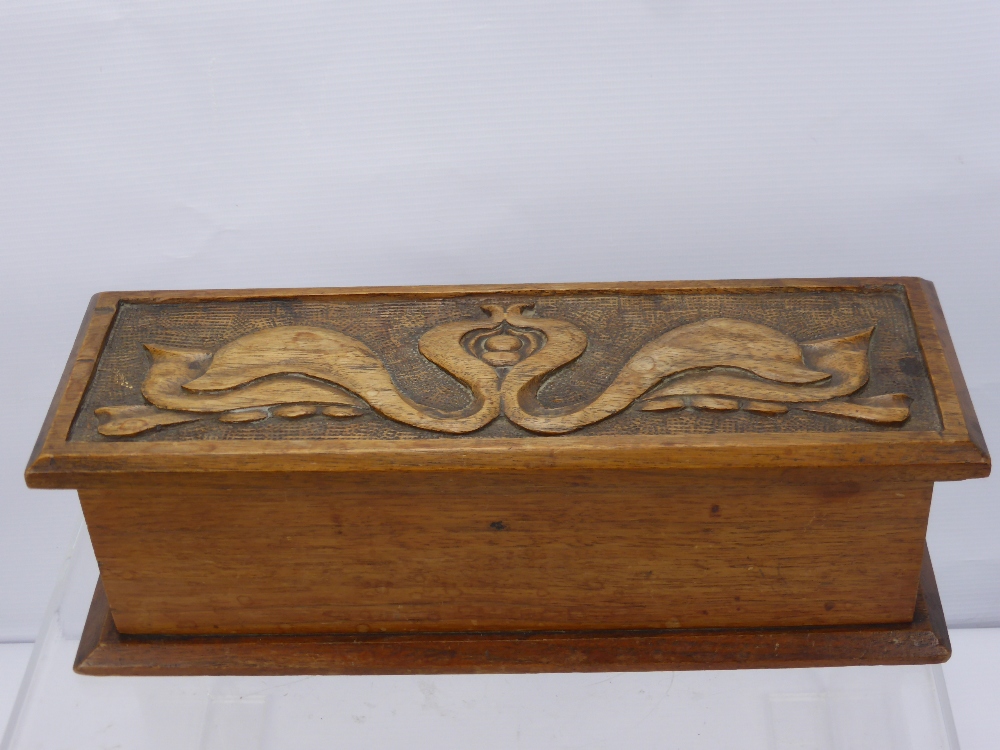 An Oak Stationery Box in the Art Nouveau style with decorative carving, architect's rolling ruler