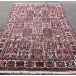 A Bakhtiar Vintage Woollen Carpet, the carpet having chequered and floral design to panels and