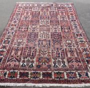 A Bakhtiar Vintage Woollen Carpet, the carpet having chequered and floral design to panels and