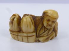 A Japanese Meiji Period Ivory Netsuke, the figure carved in the form of a merchant with baskets at