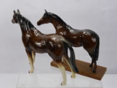 A Beswick Porcelain Figure of a Horse, together with a seated foal and two other figures of