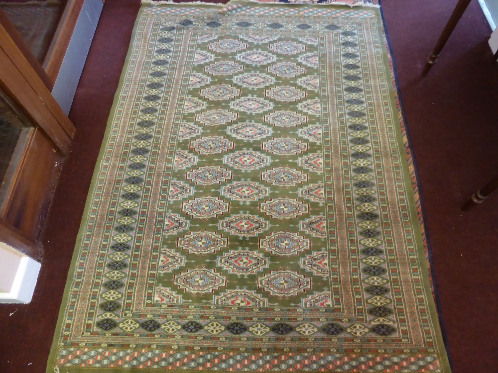A 20th Century Persian Woollen Rug, olive green and pink gül, surrounded by a floral border,