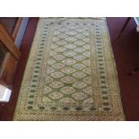 A 20th Century Persian Woollen Rug, olive green and pink gül, surrounded by a floral border,