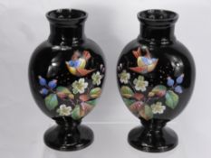 A Pair of Black Glass Painted Enamelled Vases, depicting birds and flowers, approx 28 cms high. (2)