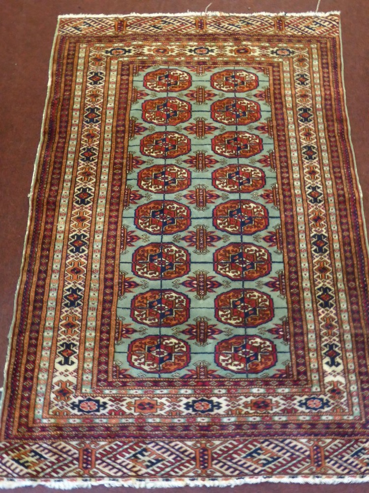 A Persian Style Carpet, with 24 central gul, with geometric border, claret design on cream ground, - Image 2 of 2