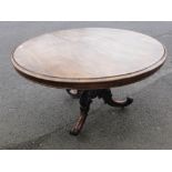 An Antique Rosewood and Mahogany Tilt Top Dining Table, on an ornately carved column and tripod base