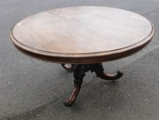 An Antique Rosewood and Mahogany Tilt Top Dining Table, on an ornately carved column and tripod base