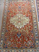 An Antique Hand Knotted Turkish Woollen Carpet, the carpet having cream, navy and burgundy