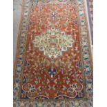 An Antique Hand Knotted Turkish Woollen Carpet, the carpet having cream, navy and burgundy